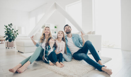 Photo of young family adopted two children move new apartments hold hands paper roof hoping best future